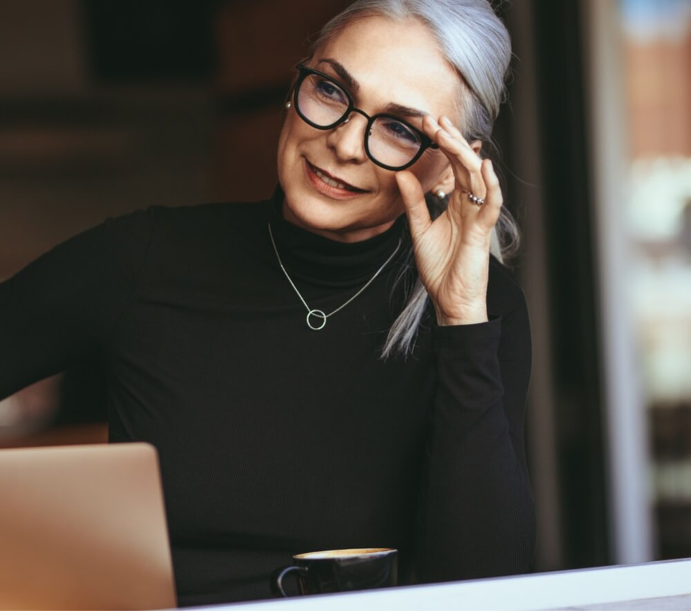 Older woman touching her glasses