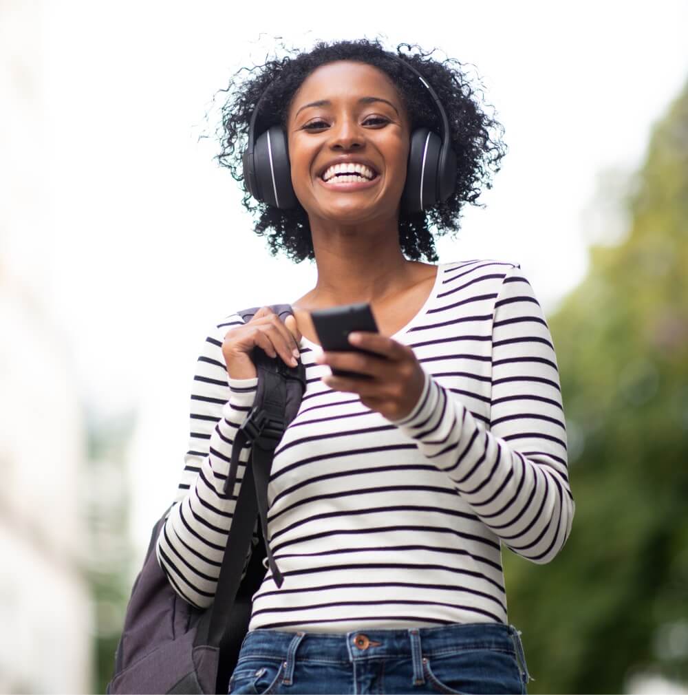 Woman wearing headphones and holding portable music player