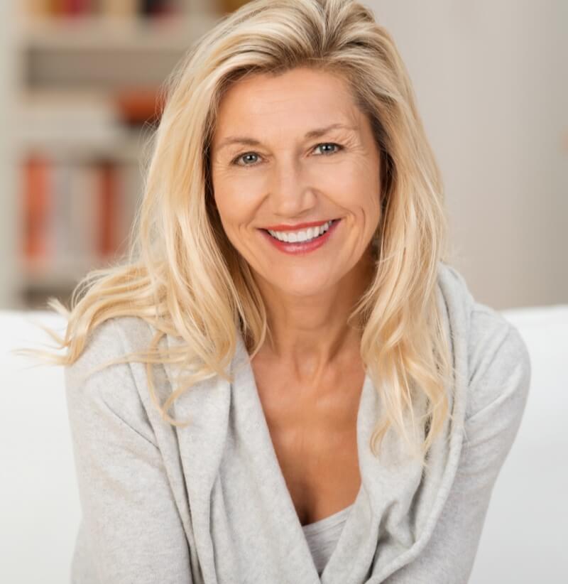 Beautiful smiling woman sitting on a sofa 