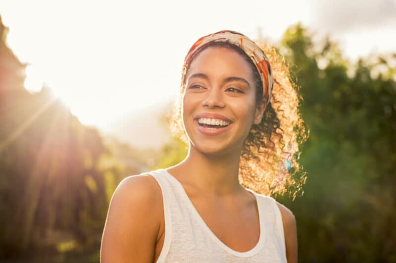 Happy cheerful girl laughing at park with colored hair band