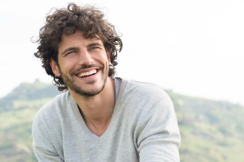 Smiling man outside with mountains in the background