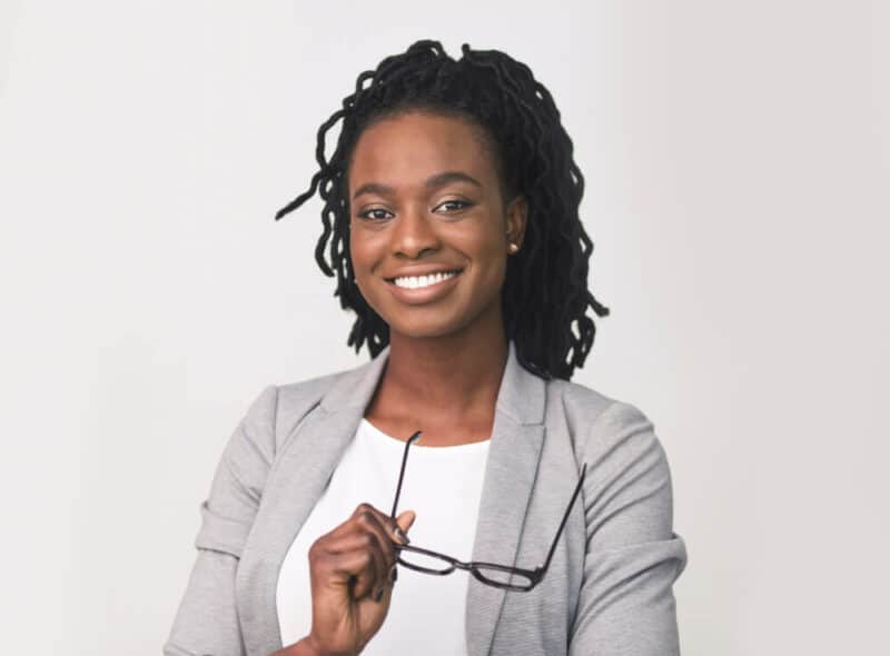 Smiling woman holding eye glasses in her hand