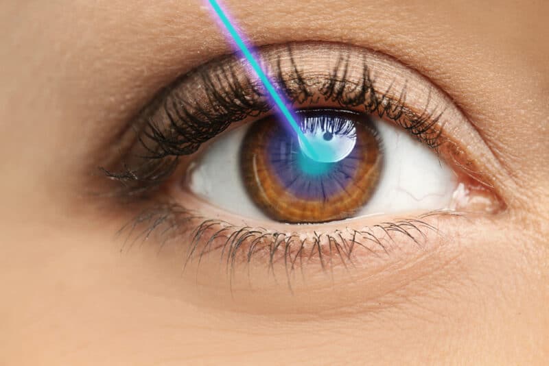 Laser and young woman, closeup of eye
